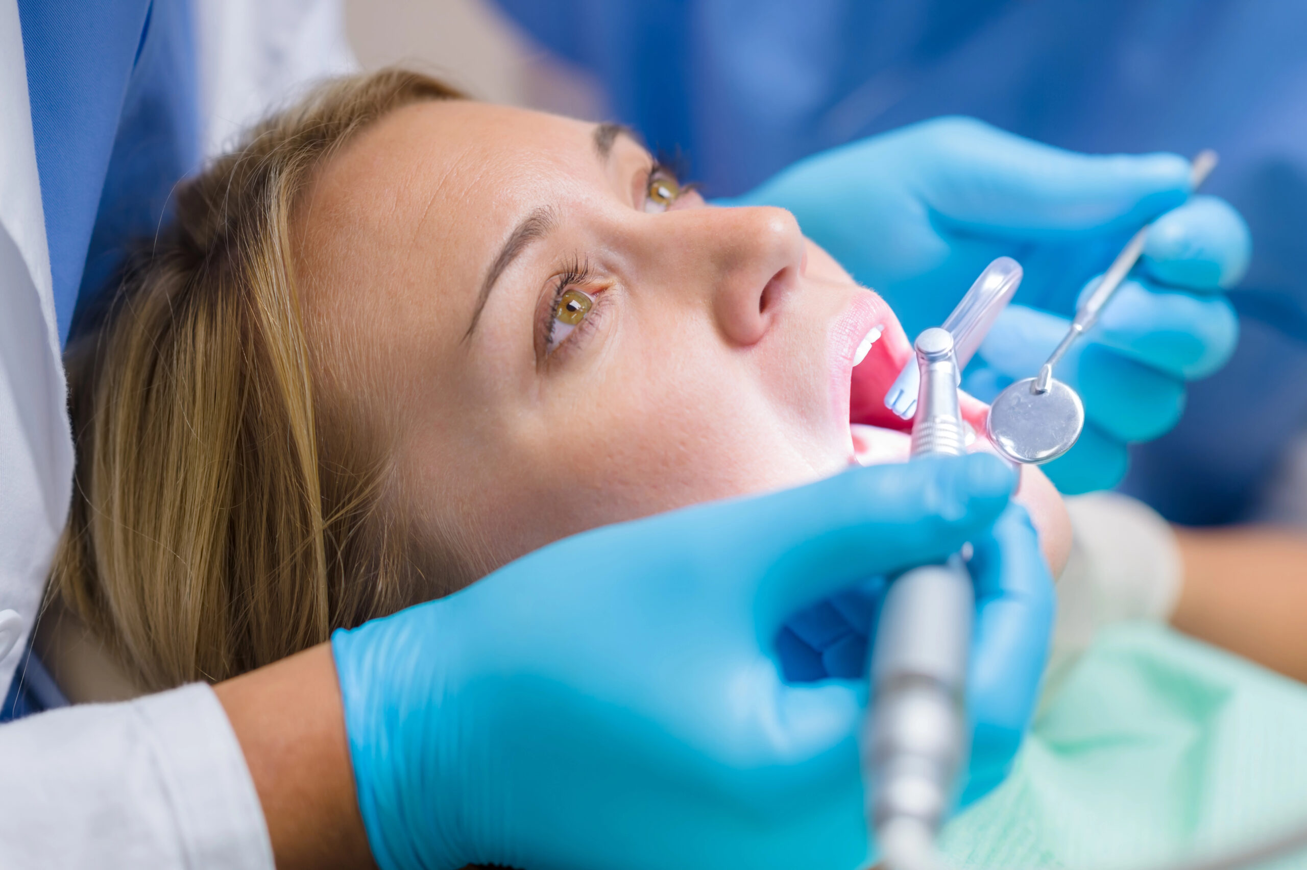 A patient receives a dental procedure with specialized tools, raising the question, "does wisdom teeth removal count as surgery," which depends on the complexity of the extraction.