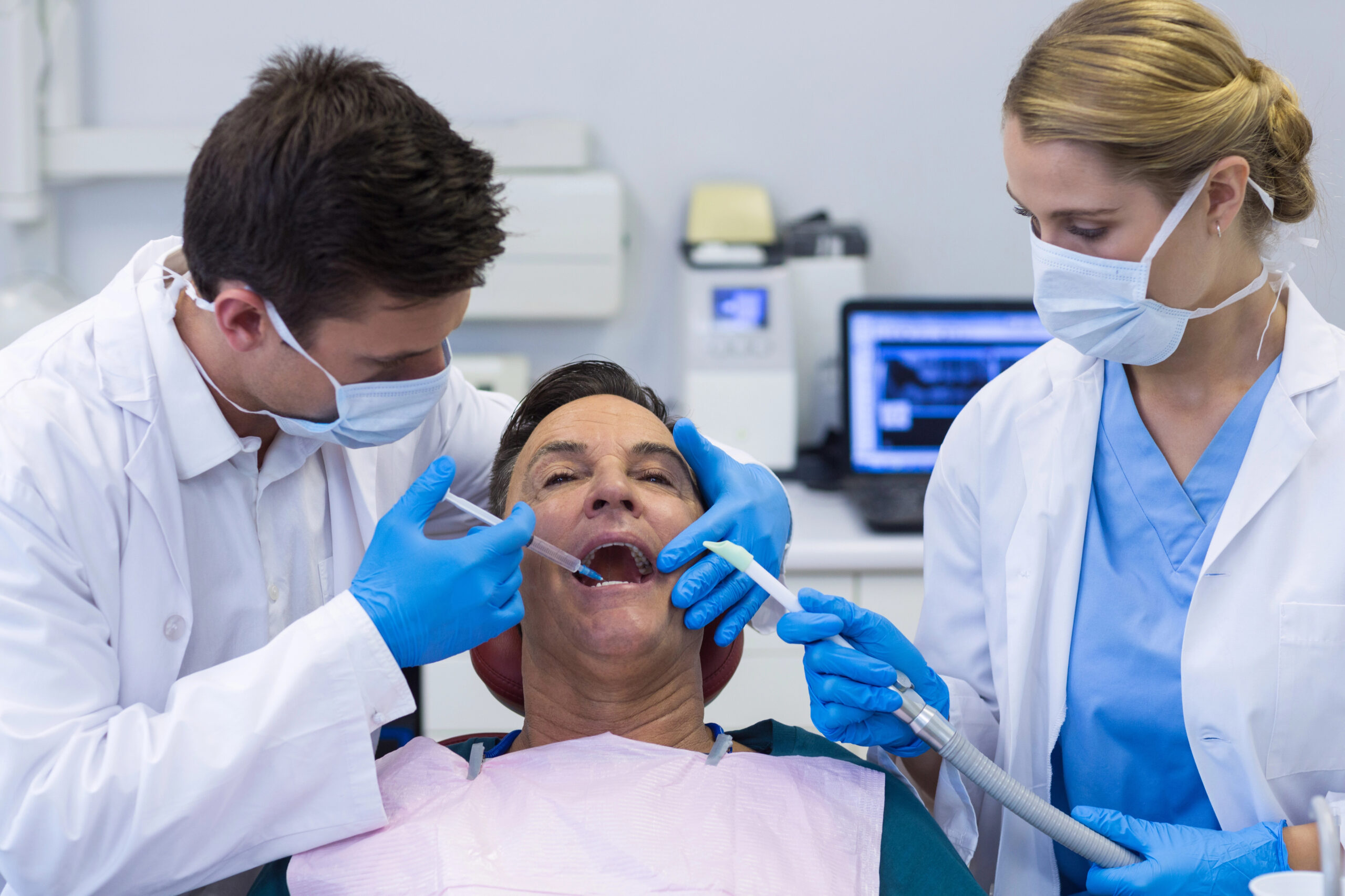 A dental team performs a procedure on a patient, showcasing general anesthesia for wisdom teeth removal to ensure a pain-free and comfortable experience.