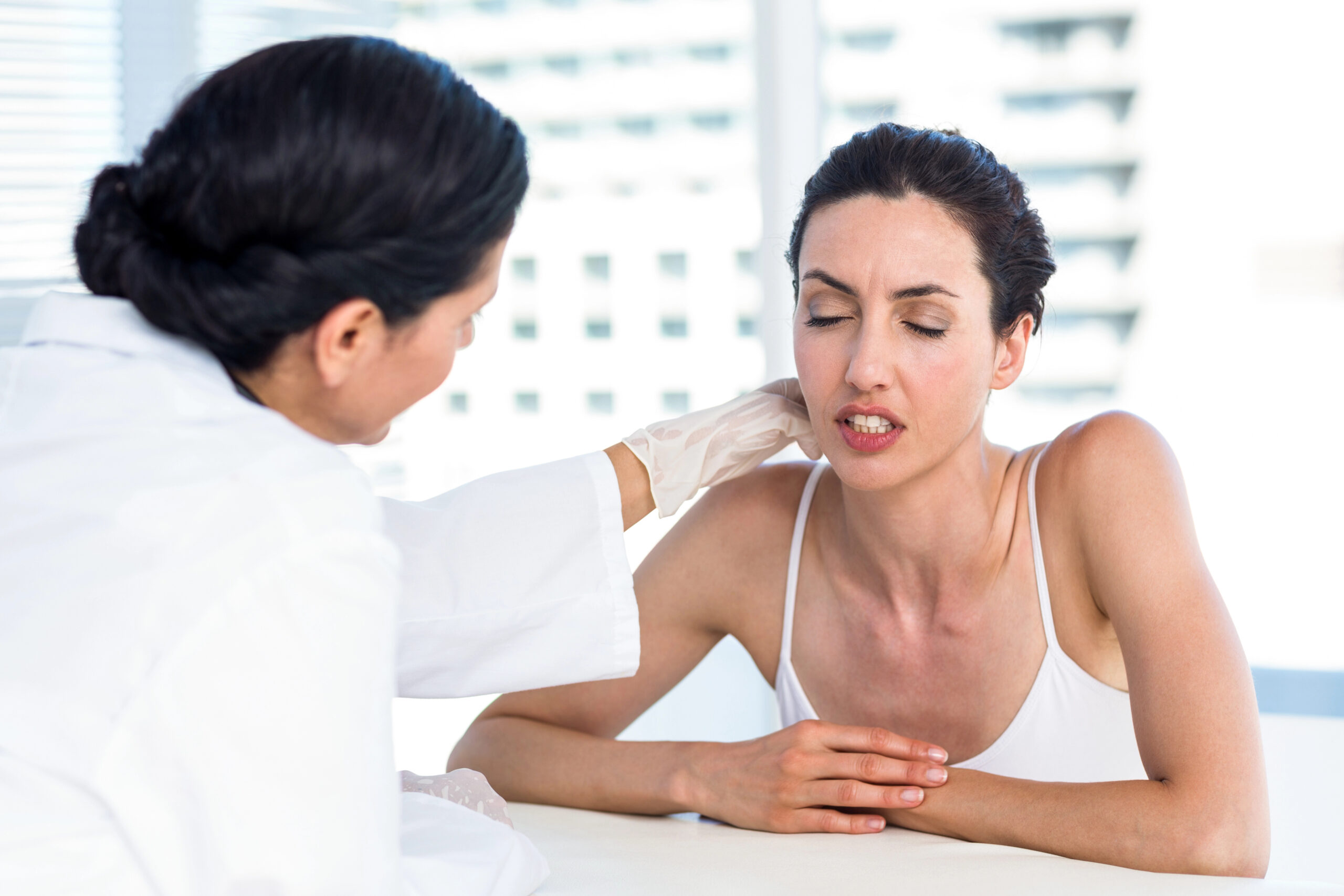 A concerned patient consults with a doctor about discomfort, potentially discussing nerve damage from wisdom teeth removal and its associated symptoms.